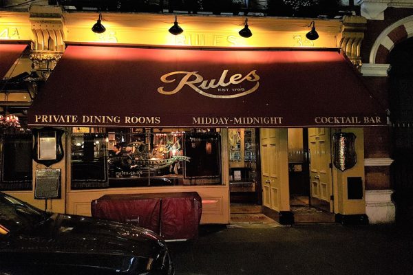 התמונה מציגה את החלק החיצוני של מסעדה עם גגון אדום המציג את השם 