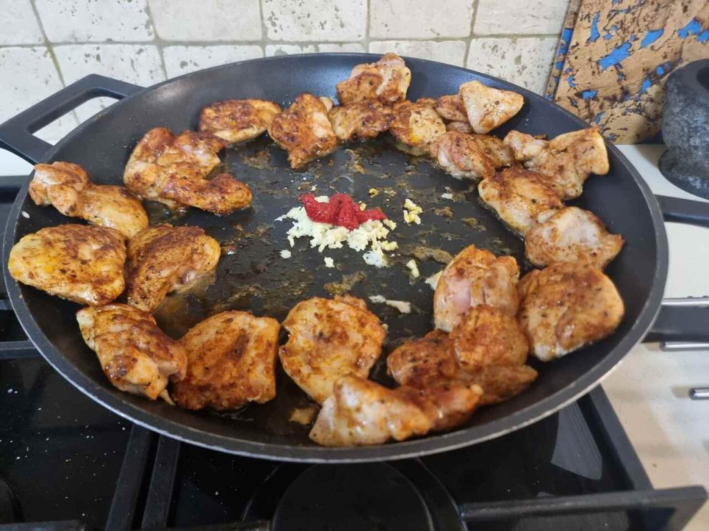 הוספת עגבניות ושום למחבת